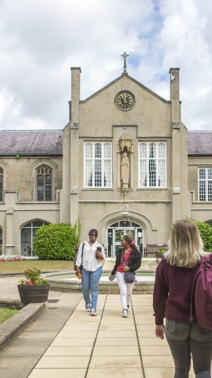 students walking through Lampeter campus grounds towards each other