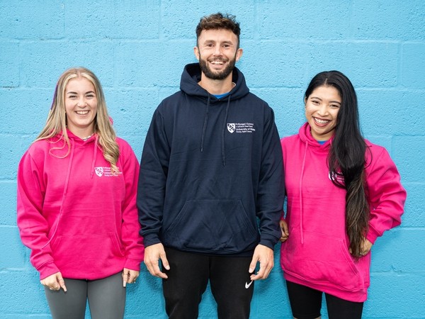 Students from the UWTSD Sports Academy wearing branded hoodies
